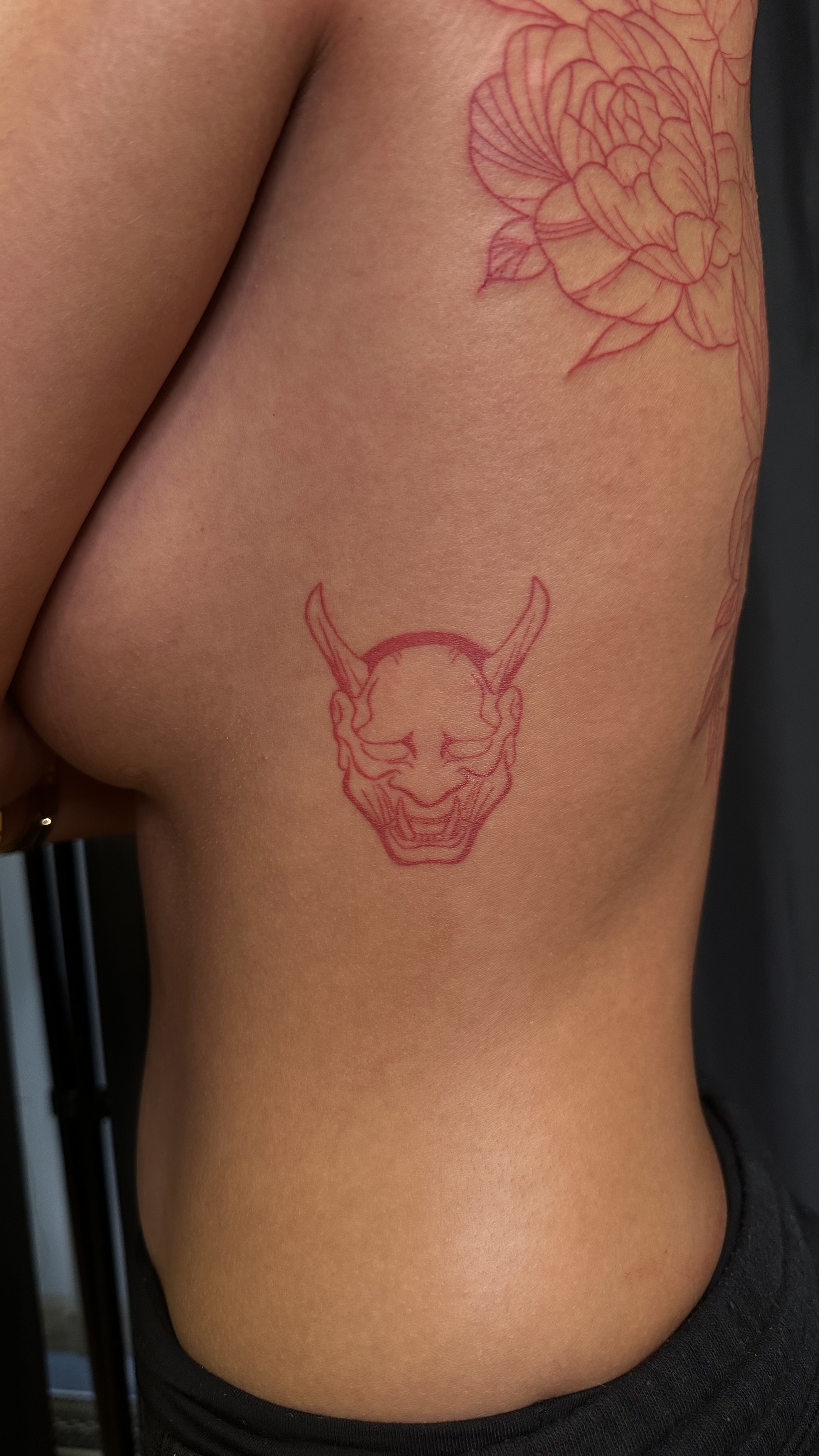 mask tattoo in red ink